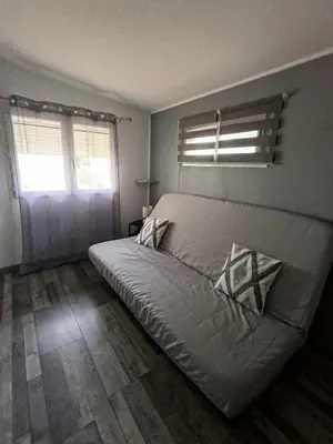 a bedroom with a bed and two windows at Maison de campagne in Lançon-Provence