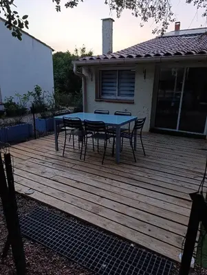 a wooden deck with a table and chairs on it at Maison de campagne in Lançon-Provence