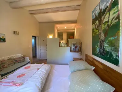 a bedroom with a bed and a large painting on the wall at Gite des amis Domaine de Mas Caron in Caromb