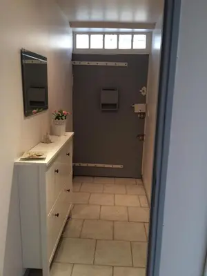 a bathroom with a door and a tiled floor at Au cœur de Céreste in Céreste
