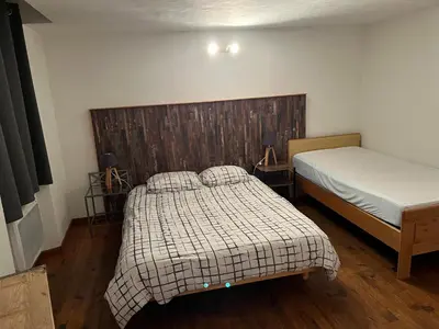 a bedroom with two beds and a wooden headboard at Maison de village - Monteux centre - Provence in Monteux