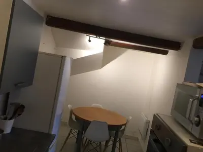a small kitchen with a small table and a tv at Maison de village - Monteux centre - Provence in Monteux