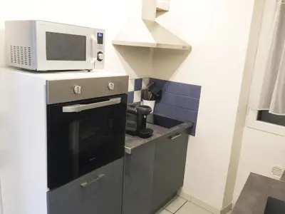 a kitchen with a microwave on top of a stove at Maison de village - Monteux centre - Provence in Monteux
