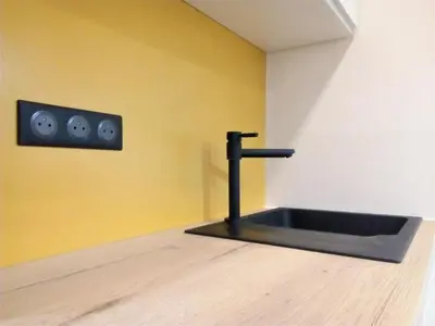 a bathroom with a sink in a room with yellow walls at Le Petit Studio - 15 m2 - Centre Ville - Sorgue à 50 m in LʼIsle-sur-la-Sorgue