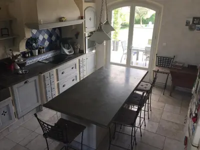 a dining room with a wooden table and a couch at Villa vue imprenable sur château in Ansouis