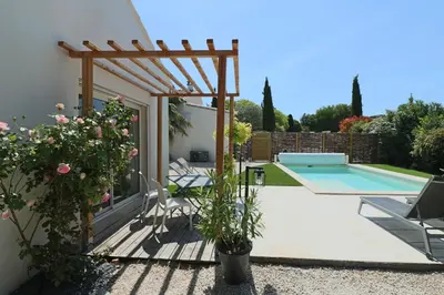a patio with a pool and a wooden pergola at Le mas Sainte Marie in Venasque