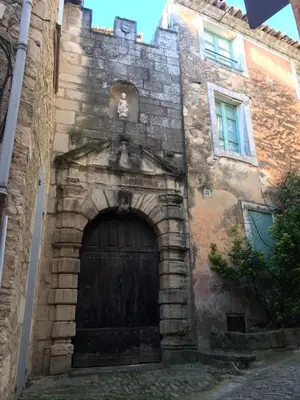 an old stone building with a large wooden door at Le Bastidon de L Olivier in Gordes