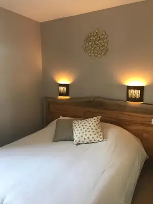 a bedroom with a bed with two lights on the wall at Le Bastidon de L Olivier in Gordes