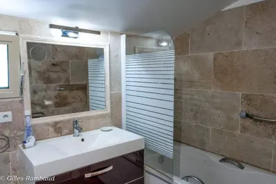 a bathroom with a sink and a mirror and a tub at Mas du Kairos - Gite Romarin in Venasque