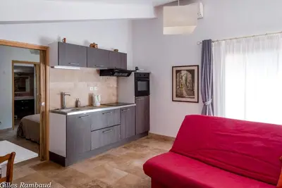 a kitchen with a red couch in a room at Mas du Kairos - Gite Romarin in Venasque