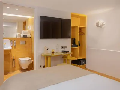 a bedroom with a bed and a bathroom with a toilet at Hôtel Saint Christophe Aix en Provence Centre Ville in Aix-en-Provence