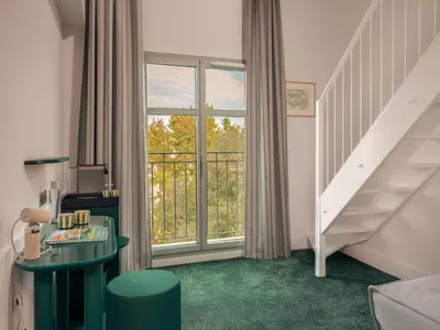 a living room with a staircase and a window at Hôtel Saint Christophe Aix en Provence Centre Ville in Aix-en-Provence