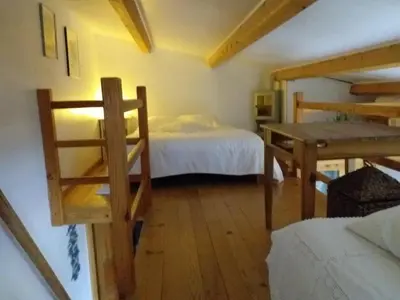 a bedroom with a bed and a desk in a room at la petite maison in Vaugines