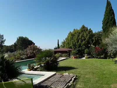a garden with a swimming pool and a lawn at la petite maison in Vaugines