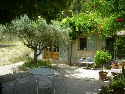 a table and chairs in front of a house at la petite maison in Vaugines
