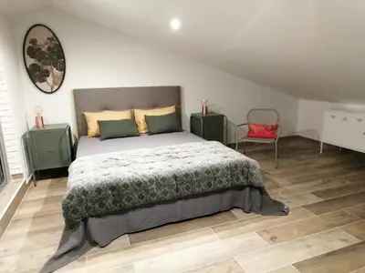 a bedroom with a bed and a red chair at LE BELVEDERE in LʼIsle-sur-la-Sorgue