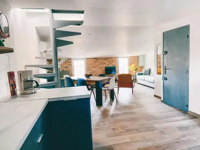a kitchen and living room with a table and chairs at LE BELVEDERE in LʼIsle-sur-la-Sorgue
