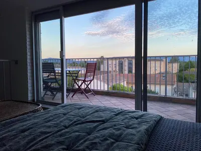 a bedroom with a bed and a view of a balcony at LE BELVEDERE in LʼIsle-sur-la-Sorgue