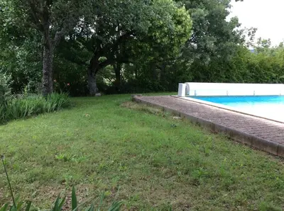 a yard with a swimming pool and trees and grass at Villa piscine face au grand luberon Cereste in Céreste