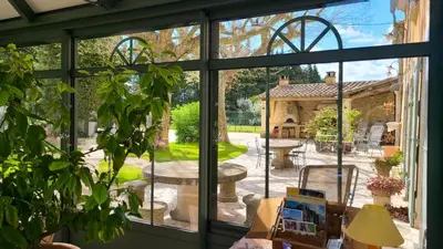 a room with a window looking out onto a patio at Maison charmante au Thor + Piscine in Le Thor