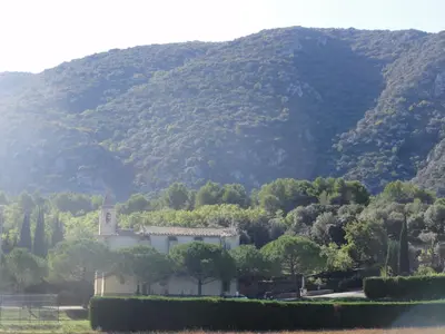 a building in front of a mountain with trees at Gite le bagnol un coin de paradis in Maubec