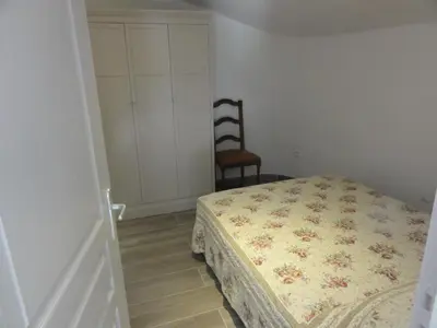 a bedroom with a bed and a chair at Gite le bagnol un coin de paradis in Maubec