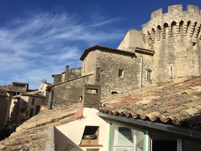 an old building with a clock tower and roofs at Chez Marius Gordes Vue panoramique sur luberon in Gordes