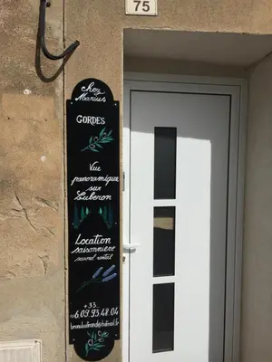 a sign on the side of a building next to a door at Chez Marius Gordes Vue panoramique sur luberon in Gordes