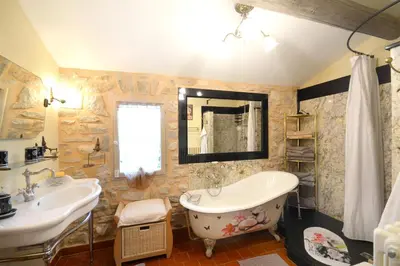 a bathroom with two sinks and a tub and a mirror at Maison Le Thor avec piscine part. in Le Thor
