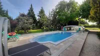 a large swimming pool with a canopy around it at Maison Le Thor avec piscine part. in Le Thor