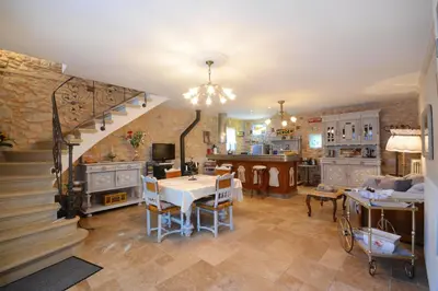 a living room with a staircase and a dining room at Maison Le Thor avec piscine part. in Le Thor