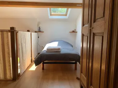a small bedroom with a bed and a skylight at La Forge - Gordes in Gordes
