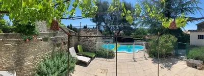 a patio with a stone wall and a swimming pool at La Forge - Gordes in Gordes