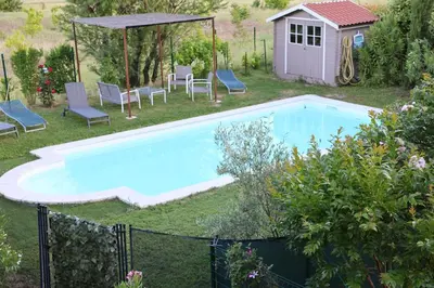 a swimming pool in a yard with chairs and a gazebo at IA ORANA in Gargas