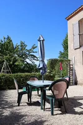 a table with two chairs and an umbrella on top at IA ORANA in Gargas