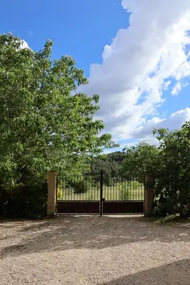 a black gate with a tree in front of it at IA ORANA in Gargas