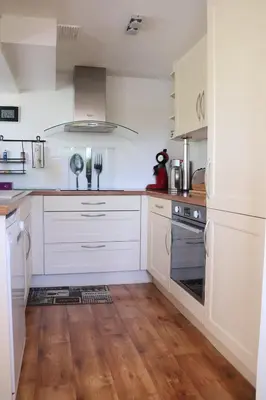 a kitchen with white appliances and wooden floors at IA ORANA in Gargas