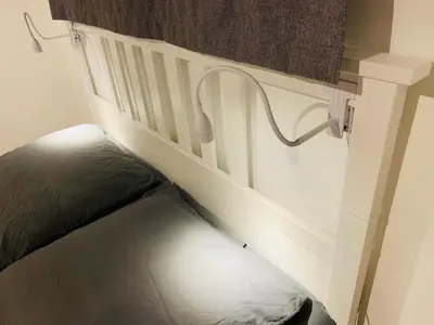 a white bed with a head board and a curtain at MAZZARIN STUDIO in Aix-en-Provence