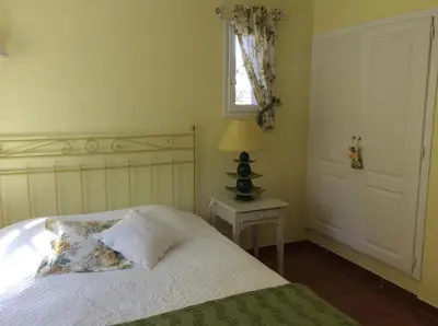 a bedroom with a bed and a lamp and a window at La Villa Rosalie in Ventabren