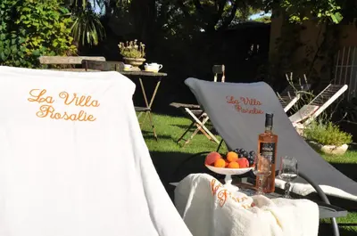 a table with two chairs and a bottle of wine at La Villa Rosalie in Ventabren