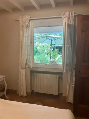 a bedroom with a window with an umbrella at La Villa Rosalie in Ventabren