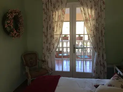 a bedroom with a bed and a window and a chair at La Villa Rosalie in Ventabren