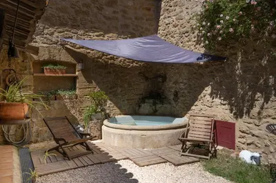 a patio with a tub and two chairs and a tent at Une Chambre en Luberon in Puyvert