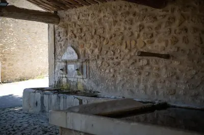 an old stone wall with a stone sink in a building at Une Chambre en Luberon in Puyvert