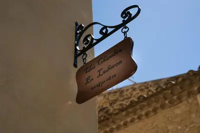 a sign hanging on the side of a building at Une Chambre en Luberon in Puyvert