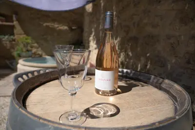 a bottle of wine and a wine glass on a barrel at Une Chambre en Luberon in Puyvert