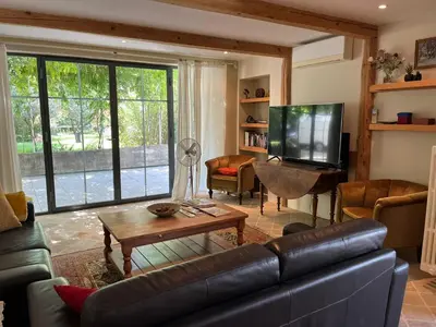 a living room with a leather couch and a television at The Willow Tree in Le Thor