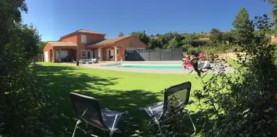 a yard with two chairs in front of a house at Chambre privée indépendante au cœur du Luberon in Saint-Saturnin-les-Apt
