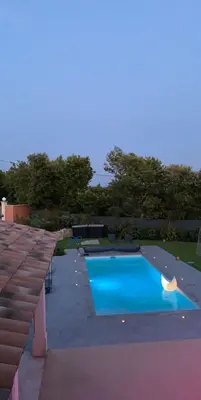 a swimming pool in a backyard with a blue pool at Chambre privée indépendante au cœur du Luberon in Saint-Saturnin-les-Apt