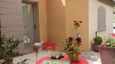 a table with two wine glasses on a patio at Maison de famille au coeur du Luberon in Mérindol